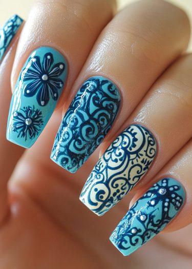 Elegant blue floral nail art with intricate designs on long almond-shaped nails.