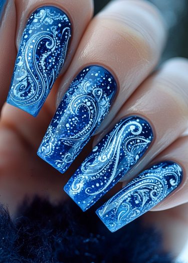 Elegant winter-themed blue nail art with intricate silver snowflake designs.