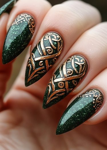 Intricate stiletto nails with shimmery green polish and copper Celtic designs create bold elegance.