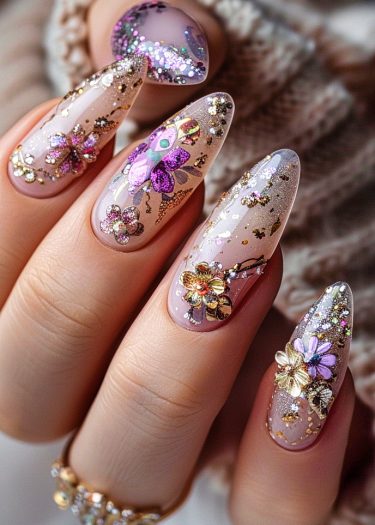 Elegant floral manicure with pink base, glitter accents, and decorative gold ring.