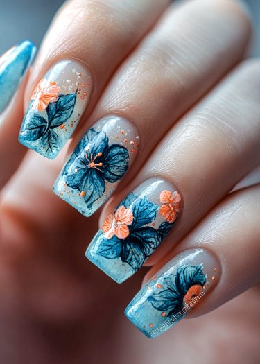 Elegant floral nail art with gradient blue background and golden speckles for a luxurious look.