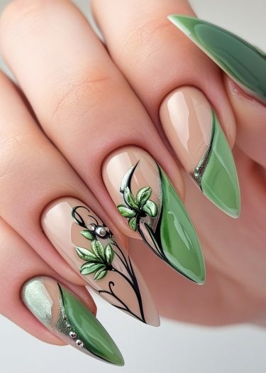 Elegant stiletto nails featuring intricate green floral designs on a nude base.