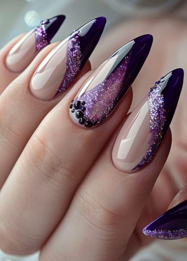 Stunning almond-shaped nails with deep purple tips and glittery accents for elegant nail art.