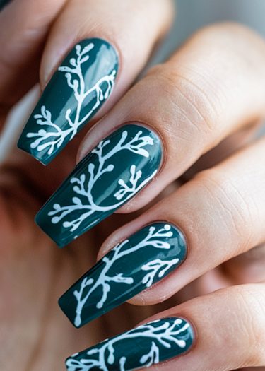 Elegant teal nails with intricate white branch designs showcasing stunning nail art creativity.