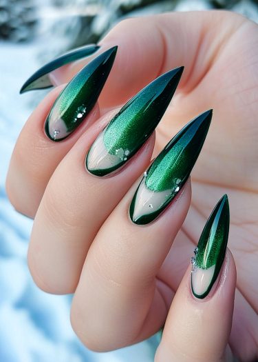 Stunning iridescent green stiletto nails with winter-themed embellishments and a glossy finish.