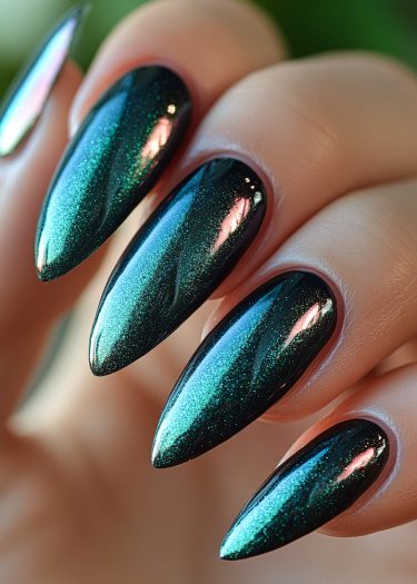 Glamorous stiletto nails with iridescent teal polish, showcasing exquisite nail art and craftsmanship.