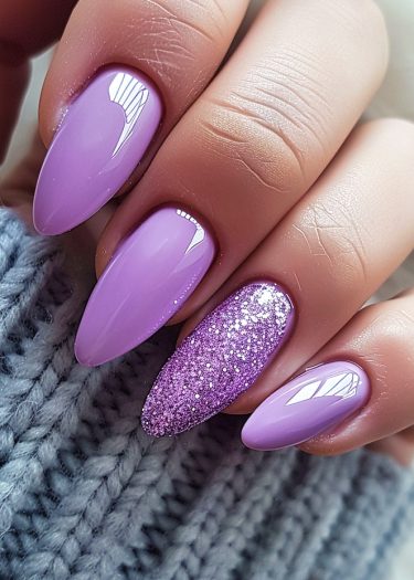 Elegant lavender almond nails with glitter design for a chic manicure look.