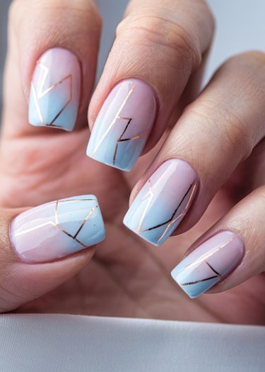 Elegant lavender and baby blue gradient nails with gold geometric accents for a chic look.