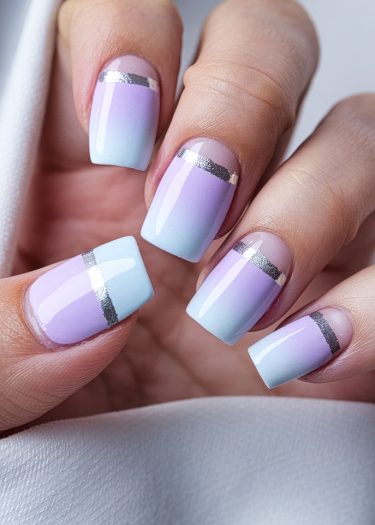 Elegant lavender and blue ombre nails with metallic stripes for a chic manicure look.