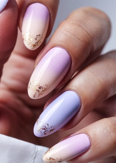 Elegant lavender ombre nails with gold foil accents for a chic manicure look.