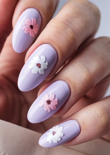 Elegant lavender floral manicure with almond-shaped nails featuring pink and white flower designs.