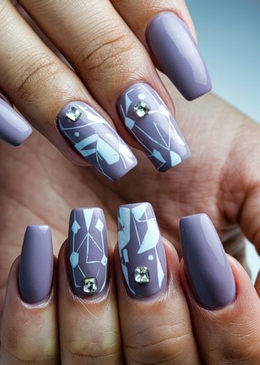 Elegant lavender-gray nail art with geometric designs and rhinestones for a stylish manicure.