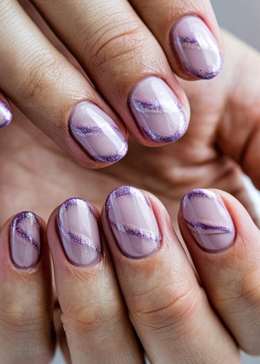 Elegant lavender nails with glitter stripes for a stylish and festive manicure.