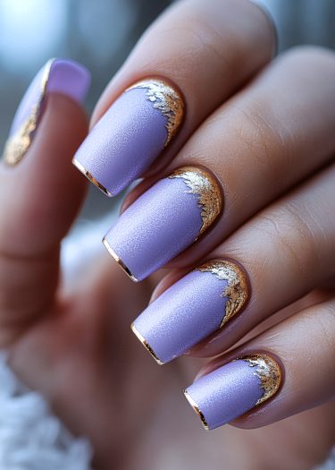 Elegant lavender nail art with gold foil detailing for a luxurious manicure look.