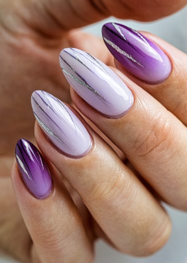 Elegant lavender gradient nails with metallic accents in almond shape for a stylish manicure.