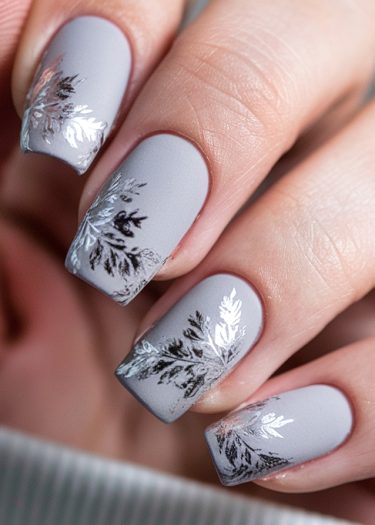 Elegant lavender-gray nail art with intricate silver foil designs on a matte finish.