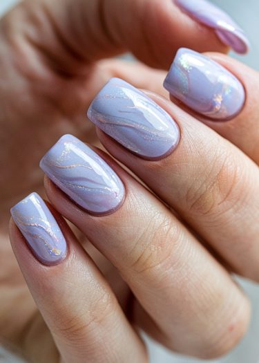 Elegant lavender manicure with swirling iridescent glitter designs on beautifully shaped nails.