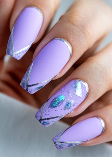 Elegant lilac coffin nails with silver accents and glamorous glitter details for stylish nail art.