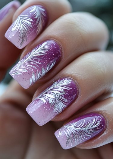 Lavender pink ombre nails with silver feather designs and glitter accent for stunning nail art.