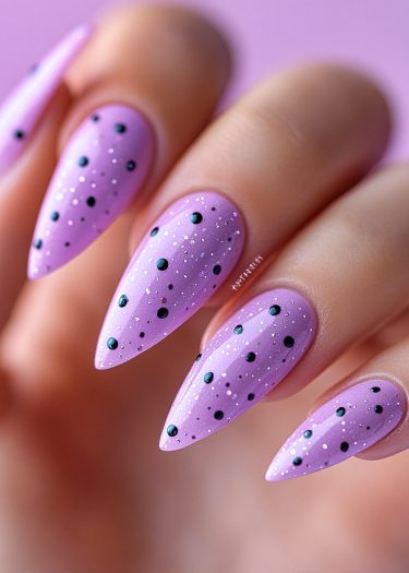 Lavender polka dot nails with glitter, showcasing elegant manicured almond-shaped design.