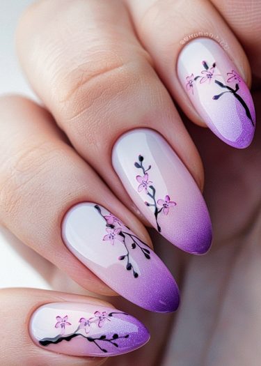 Elegant lavender-purple gradient nail art featuring delicate cherry blossom designs.