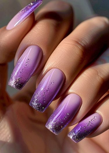 Elegant lavender and purple gradient nails with glitter, showcasing a chic coffin shape.