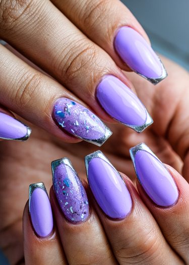 Vibrant lavender and silver nail art with glitter accents for elegant, trendy manicure style.