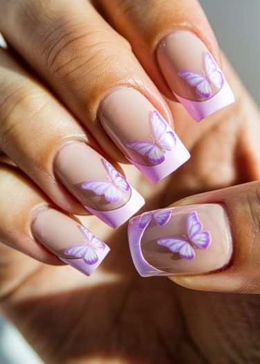 Elegant lavender-tipped manicure with intricate butterfly nail art on a nude base.