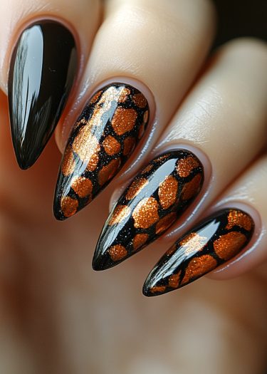 Glossy black and glittery orange leopard print stiletto nails for bold nail art fashion.