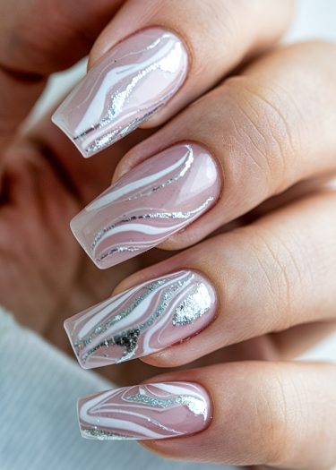 Elegant light pink nail art with unique silver swirling designs for a stylish look.