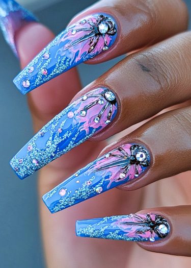 Stunning long blue marble nails with floral designs and sparkling crystals for elegant style.