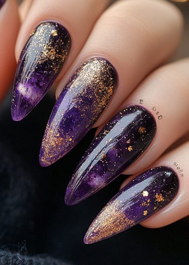 Stunning purple stiletto nails with gold glitter and celestial design for a bold look.