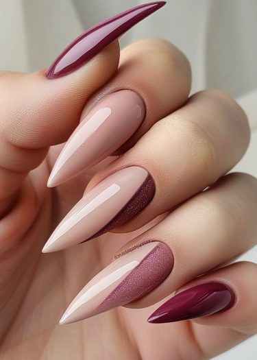 Elegant stiletto nails in ombré shades of nude and burgundy with glossy and matte finishes.