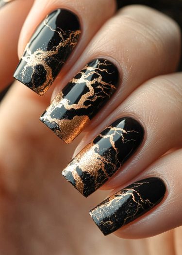 Elegant black and gold nail art design with crackle patterns on beautifully manicured nails.