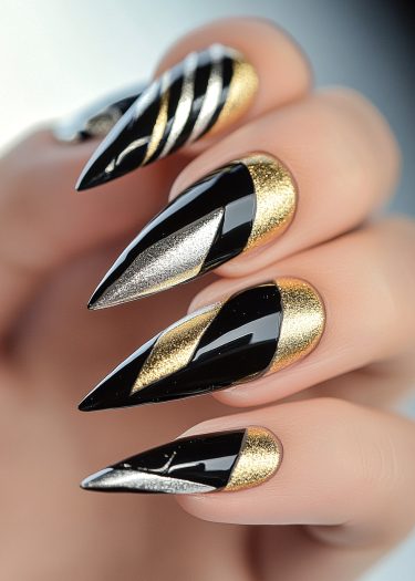 Almond-shaped luxury stiletto nails featuring geometric black, gold, and silver designs.