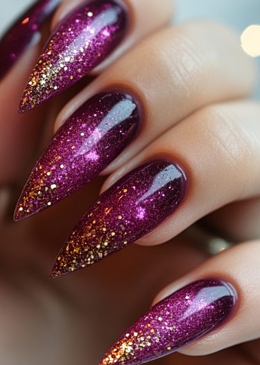 Stylish magenta stiletto nails with glitter gradient for a luxurious manicure.