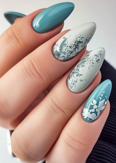 Elegant teal and green nail art with floral designs and silver foil accents.