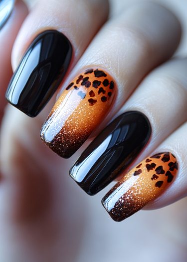 Stunning coffin nails with black and orange gradient and leopard print design for trendy manicure.