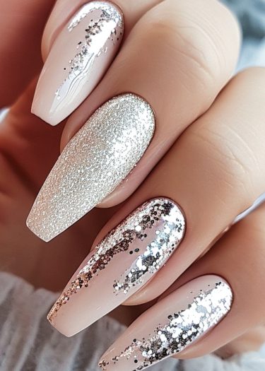 Elegant coffin-shaped nails with glitter art in soft nude pink for a chic look.