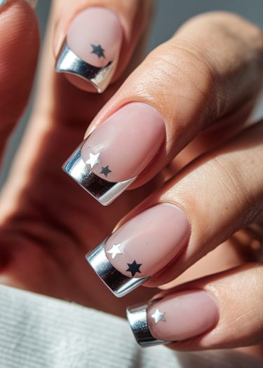 Modern pink manicure with metallic silver tips and star decals for a stylish look.