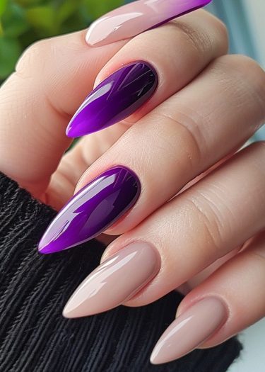 Elegant purple and nude stiletto nails showcase stunning nail art in a refined setting.