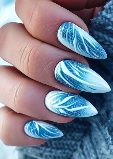 Elegant stiletto nails with blue shimmer and white feather patterns, perfect for winter aesthetics.