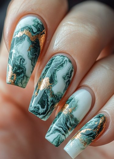 Elegant green marble nails with metallic gold accents create a stunning, artistic manicure.