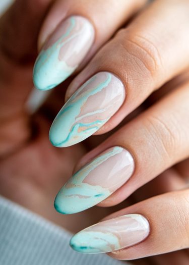 Elegant marbled pastel nails in mint green and beige with glossy finish.