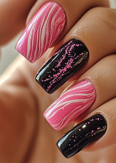 Creative pink and black nail art featuring marbled designs and playful speckles.