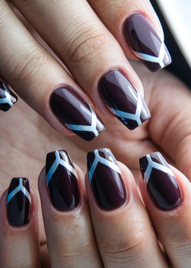 Elegant maroon geometric nail art with metallic designs for a sophisticated manicure look.