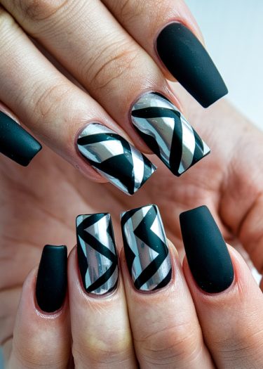 Chic matte black geometric nail art with reflective silver patterns for a stylish look.