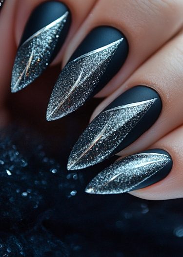 Elegant matte black stiletto nails with silver glitter design for striking nail art inspiration.