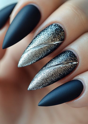 Dramatic matte black stiletto nails with sparkling silver glitter and metallic accents for an edgy look.