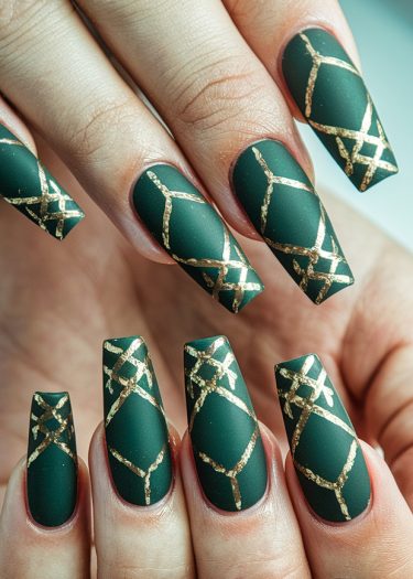 Elegant matte green nails with gold geometric patterns, showcasing sophisticated nail art design.